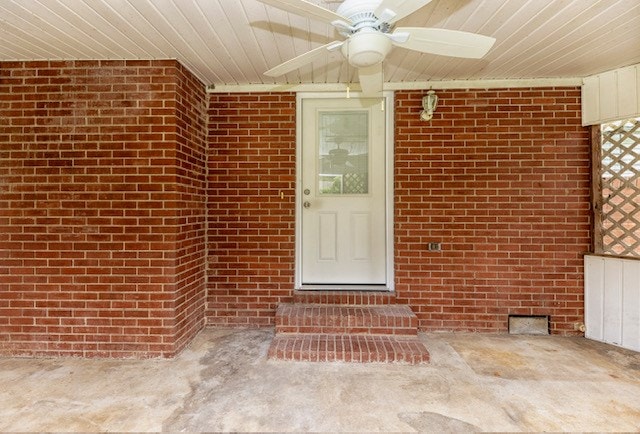 entrance to property with ceiling fan and a patio area