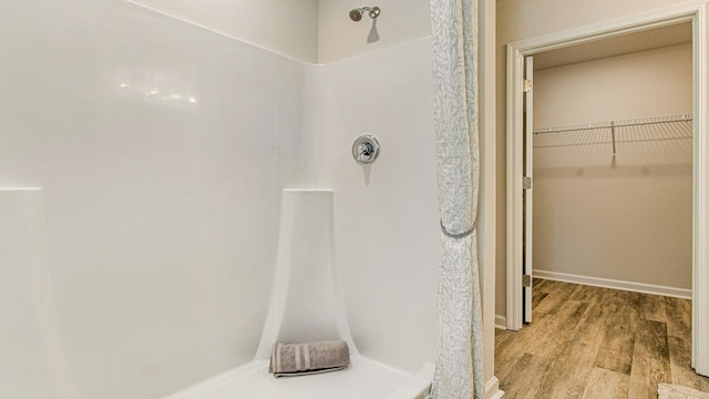 bathroom featuring hardwood / wood-style flooring and walk in shower