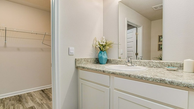 bathroom with vanity, wood-type flooring, and a textured ceiling