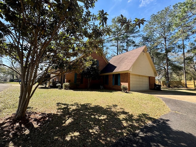 view of front of property with brick siding, a front yard, an attached garage, and aphalt driveway