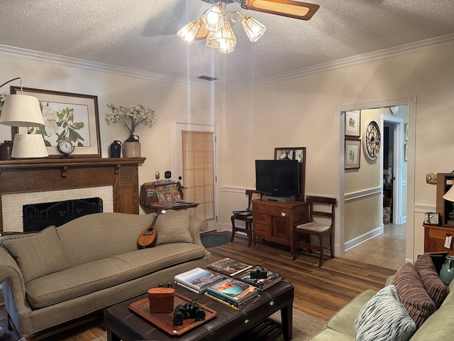 living area featuring ornamental molding, a fireplace, and a textured ceiling