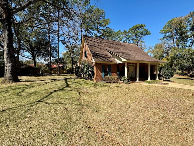 exterior space with brick siding and a yard