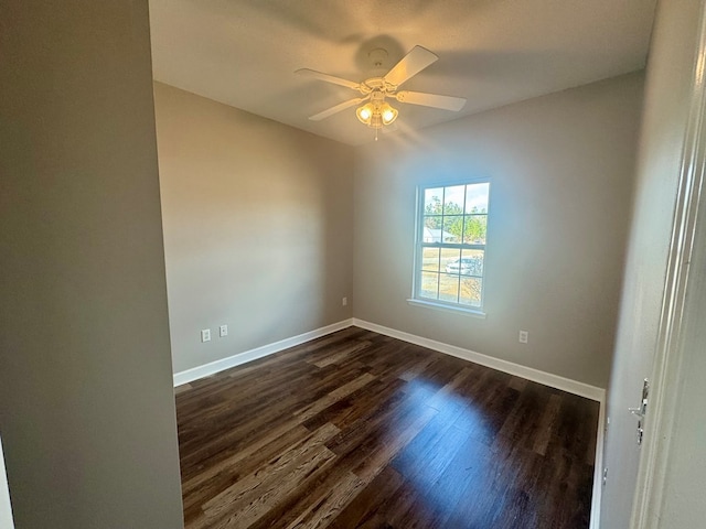 empty room with dark hardwood / wood-style flooring and ceiling fan