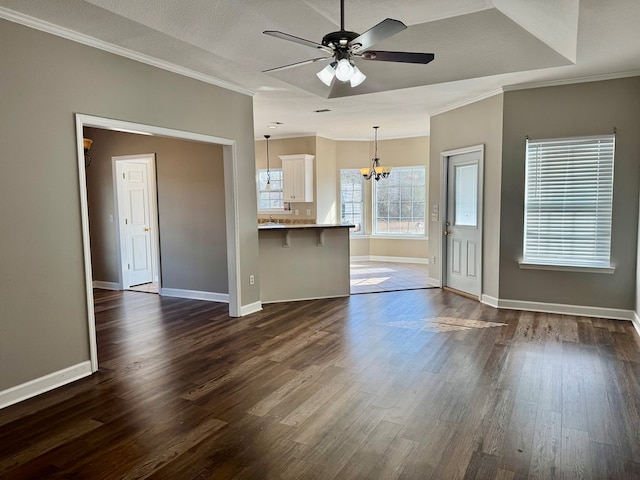 unfurnished living room featuring ornamental molding, dark hardwood / wood-style floors, ceiling fan with notable chandelier, and a textured ceiling