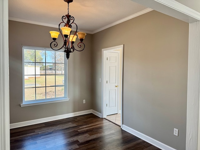 unfurnished dining area featuring crown molding, an inviting chandelier, and dark hardwood / wood-style flooring