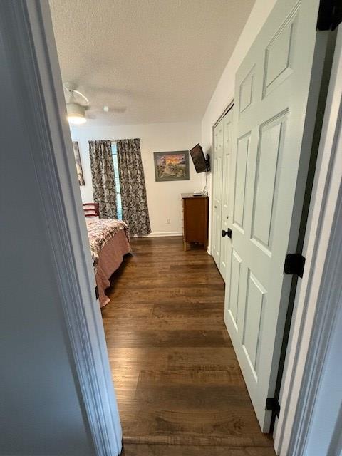 corridor featuring dark hardwood / wood-style floors and a textured ceiling