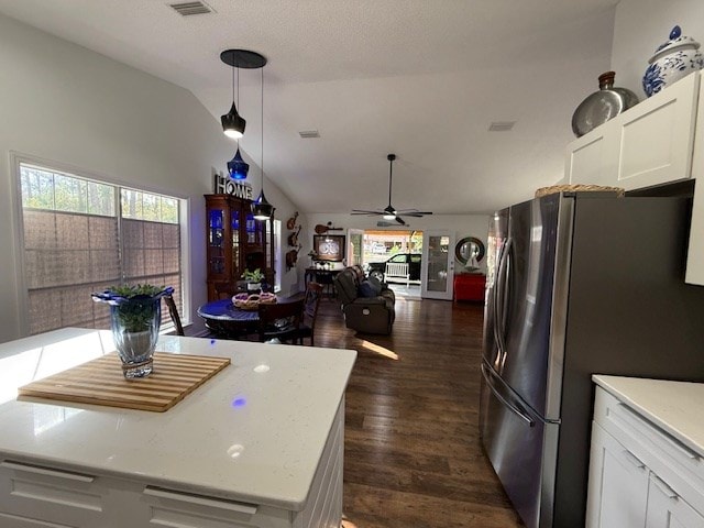 kitchen with stainless steel fridge, vaulted ceiling, ceiling fan, decorative light fixtures, and white cabinets