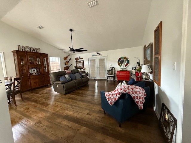 living room with ceiling fan, french doors, dark hardwood / wood-style floors, and lofted ceiling