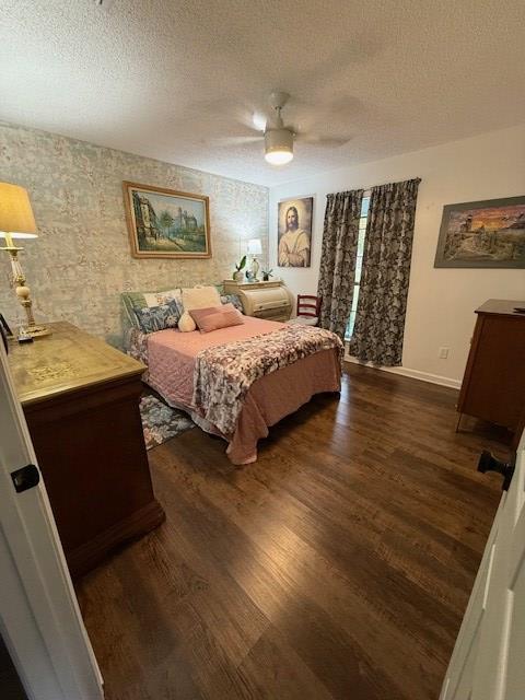 bedroom featuring a textured ceiling, ceiling fan, and dark wood-type flooring