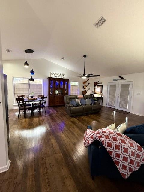 living room with vaulted ceiling, ceiling fan, and dark wood-type flooring