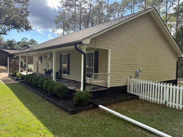 view of home's exterior with covered porch and a yard