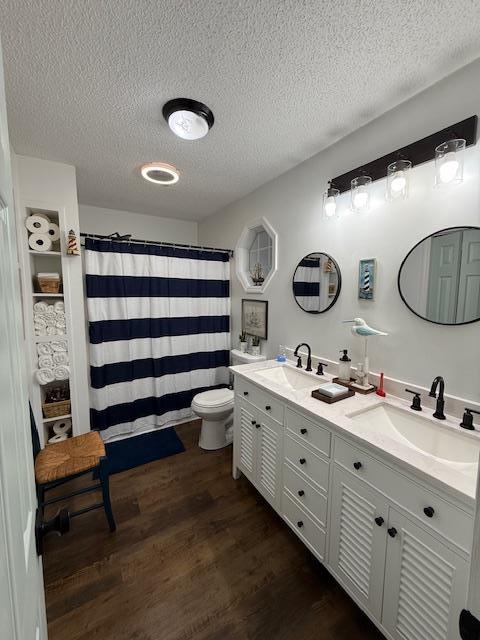 bathroom featuring vanity, a shower with shower curtain, toilet, a textured ceiling, and wood-type flooring