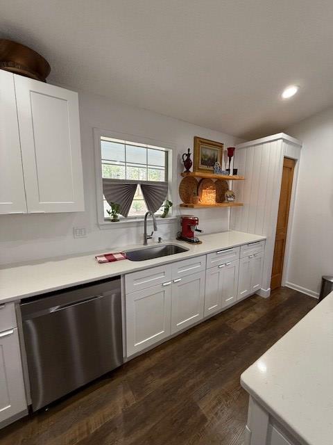 kitchen with dark wood-type flooring, sink, white cabinets, and stainless steel dishwasher