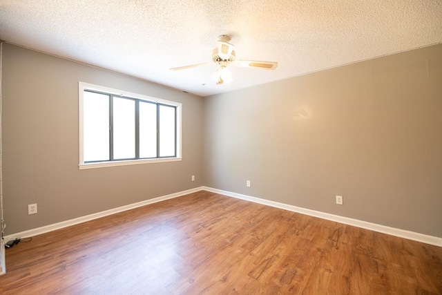 unfurnished room with ceiling fan, wood-type flooring, and a textured ceiling