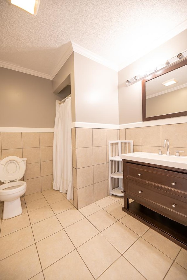 bathroom with a textured ceiling, toilet, crown molding, and tile walls