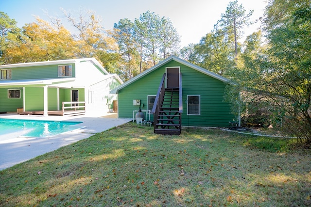 rear view of property featuring a patio area and a yard