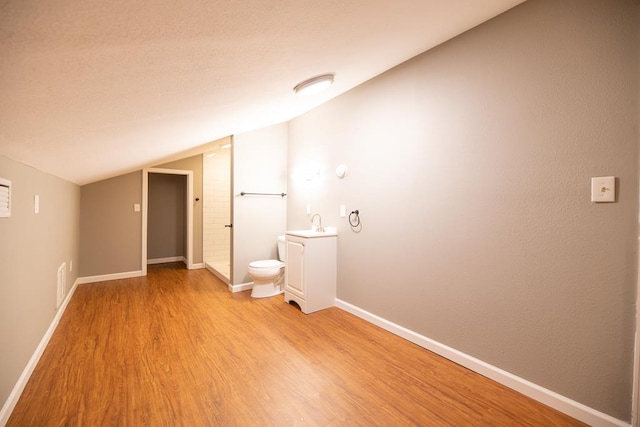 interior space with light wood-type flooring, lofted ceiling, and sink