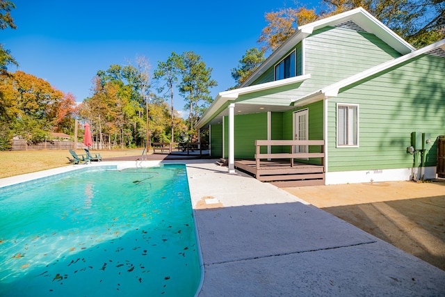 view of swimming pool featuring a patio area and a wooden deck