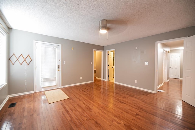 unfurnished room with ceiling fan, a textured ceiling, and hardwood / wood-style flooring