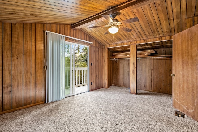 unfurnished bedroom with vaulted ceiling with beams, ceiling fan, wooden walls, carpet flooring, and access to outside