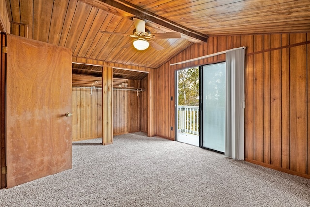 interior space with wooden walls, wooden ceiling, vaulted ceiling with beams, and carpet flooring