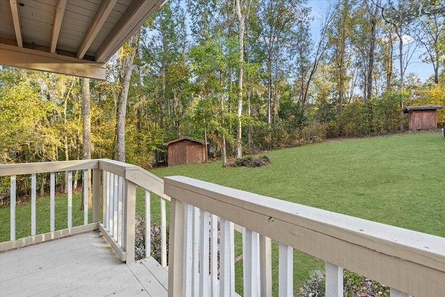 wooden terrace featuring a lawn and a storage shed