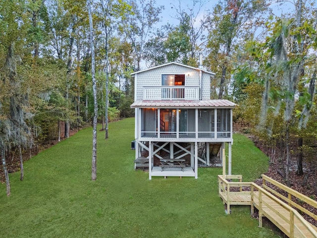 view of outdoor structure featuring a yard and a sunroom