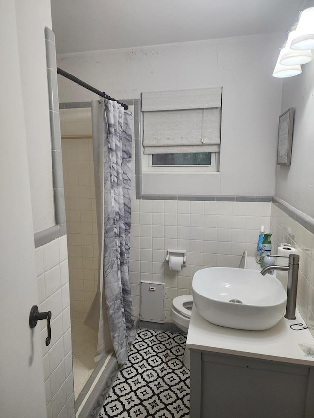 358/356 Hull St, Colquitt, GA 39837 - full bath with vanity, a stall shower, tile walls, and wainscoting