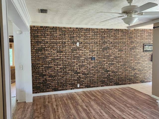 358/356 Hull St, Colquitt, GA 39837 - unfurnished room with ceiling fan, ornamental molding, wood finished floors, a textured ceiling, and brick wall