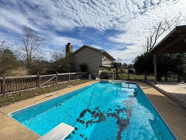 view of swimming pool featuring a diving board