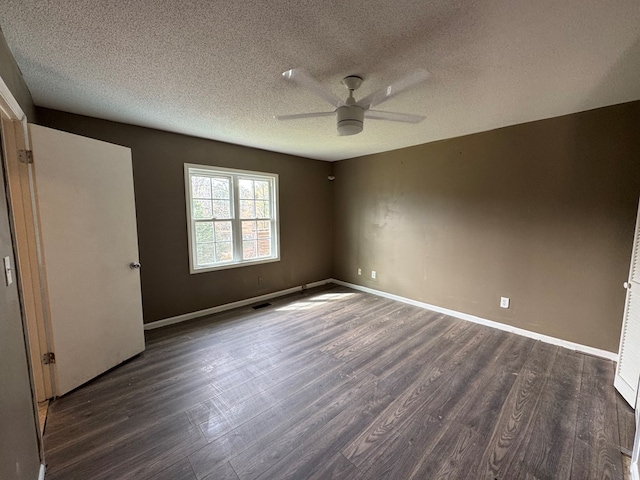 empty room featuring dark hardwood / wood-style flooring, a textured ceiling, and ceiling fan