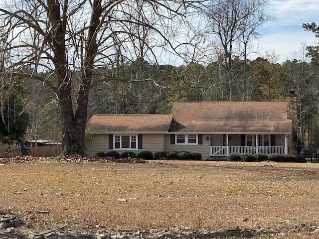 ranch-style home featuring a porch and a front lawn