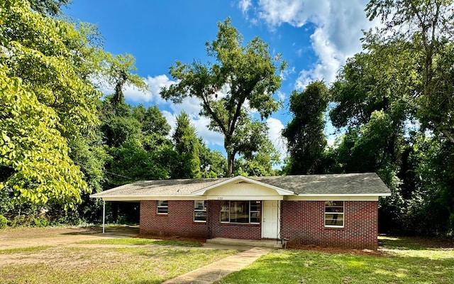 single story home with a front lawn and a carport