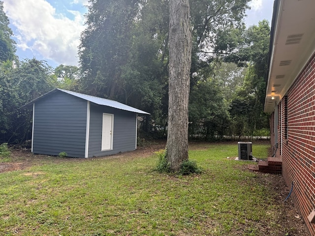 view of yard featuring central AC and a storage unit