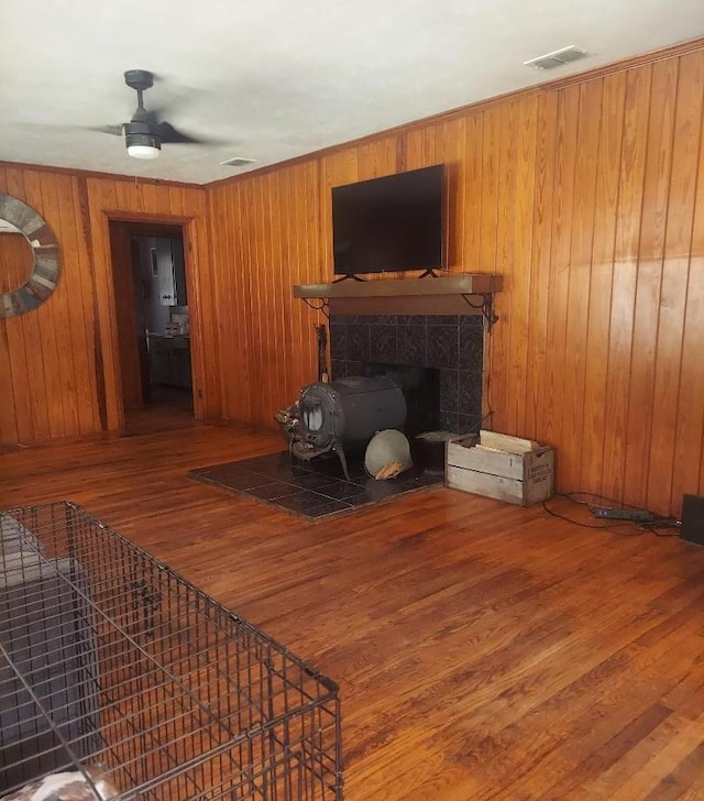 910 S Broad St, Cairo, GA 39828 - living room featuring wood finished floors, a ceiling fan, a fireplace, and wood walls