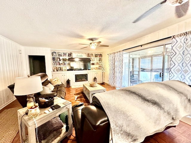 bedroom with access to outside, ceiling fan, and a textured ceiling