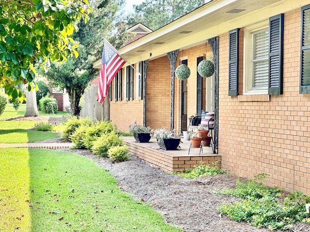 view of side of property featuring a lawn and a patio area