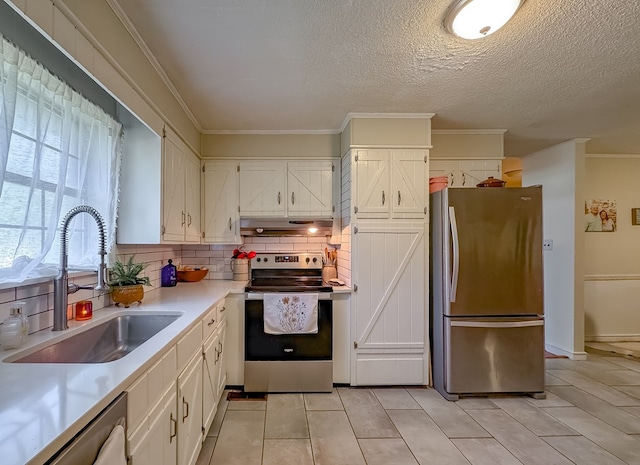 kitchen with a sink, white cabinets, under cabinet range hood, appliances with stainless steel finishes, and tasteful backsplash