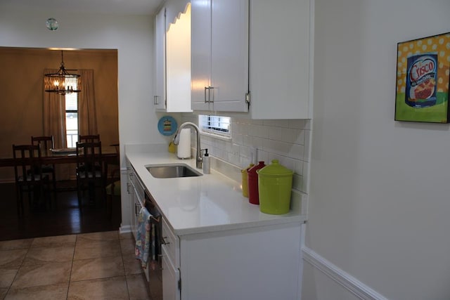 kitchen featuring pendant lighting, white cabinets, a sink, and light countertops