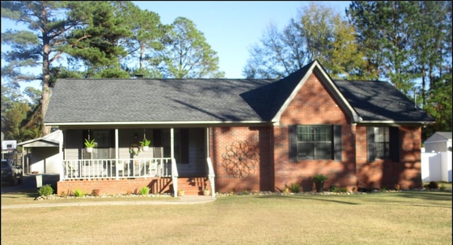 view of front facade featuring covered porch, brick siding, and a front lawn