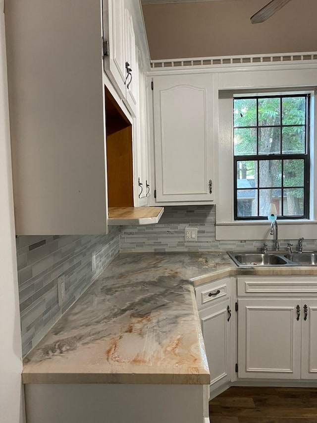 709 E College St, Bainbridge, GA 39817 - kitchen featuring a sink, tasteful backsplash, white cabinets, dark wood-style flooring, and light countertops