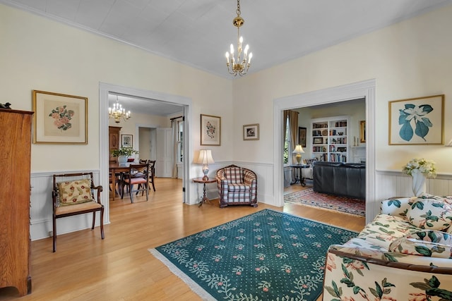 living room featuring hardwood / wood-style floors, ornamental molding, and a notable chandelier