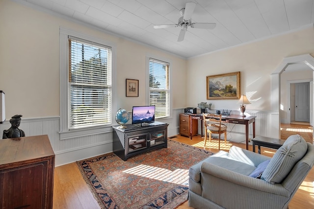 living room featuring light wood-type flooring, ceiling fan, and ornamental molding