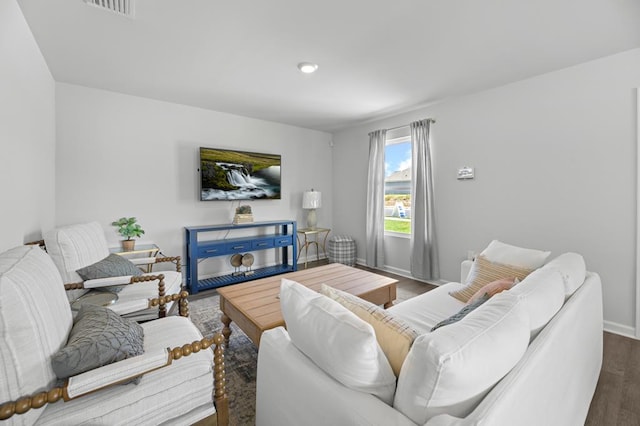 living area with wood finished floors, visible vents, and baseboards