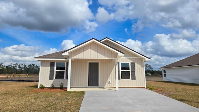 view of front of home featuring a front lawn and a shingled roof