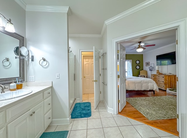 bathroom with crown molding, ceiling fan, wood-type flooring, and a shower with shower door