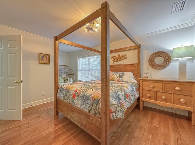 bedroom featuring light hardwood / wood-style flooring and crown molding