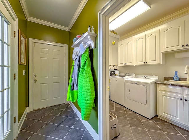 laundry room with dark tile patterned floors, cabinets, separate washer and dryer, and sink