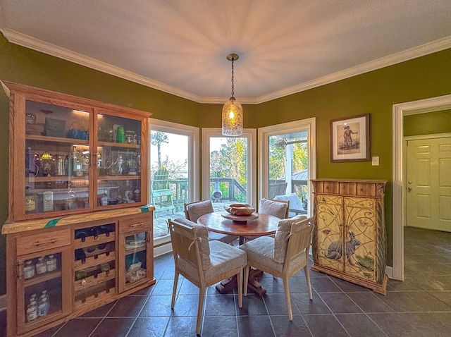 tiled dining space with ornamental molding, a textured ceiling, and a healthy amount of sunlight