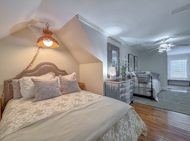 bedroom featuring hardwood / wood-style floors, vaulted ceiling, ceiling fan, and ornamental molding